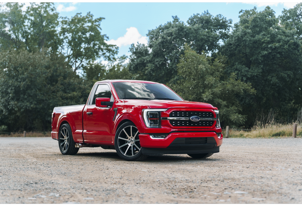 Red pickup truck in a scenic outdoor setting.