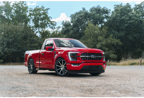 Red pickup truck in a scenic outdoor setting.