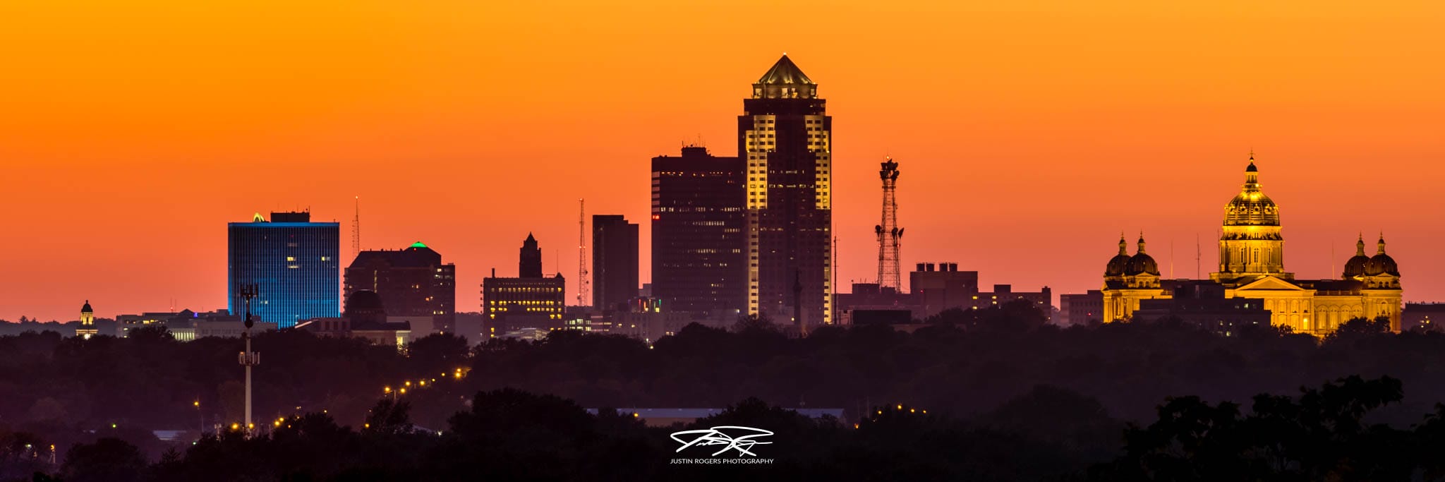 Des Moines skyline at sunset with orange sky.