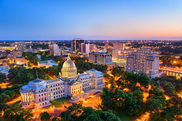 Jackson skyline at sunset with illuminated capitol building.