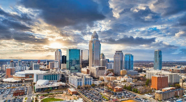 Charlotte skyline at sunset with tall buildings.