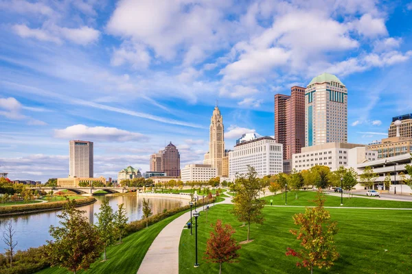 Columbus skyline with grassy park and river view.