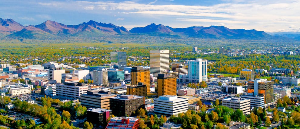 Aerial view of cityscape with mountains in background.