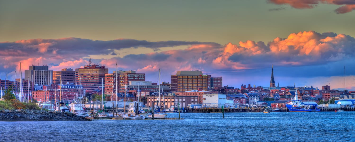 Portland Maine skyline at sunset with harbor view.