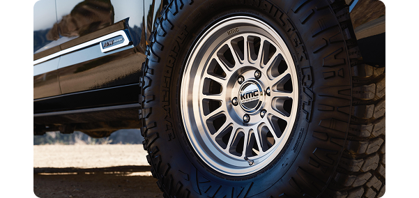 Off-road vehicle with KMC tire on rugged terrain.