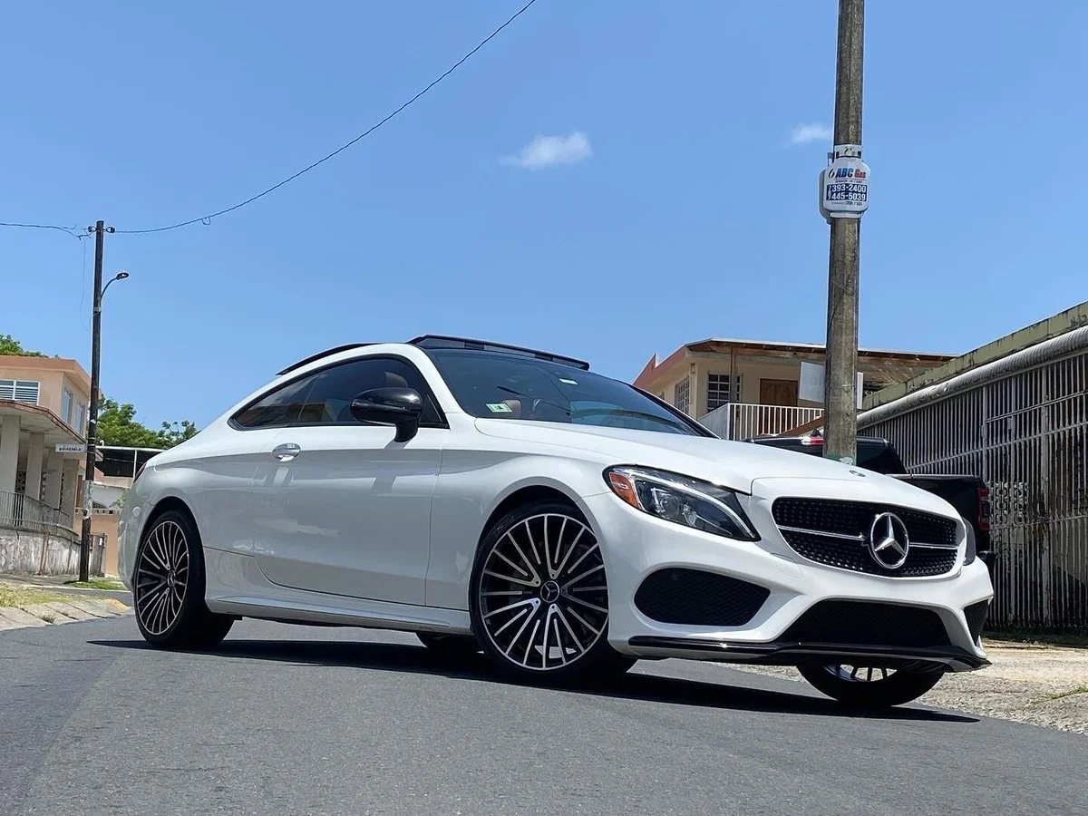 White Mercedes coupe parked on street under blue sky. custom wheels