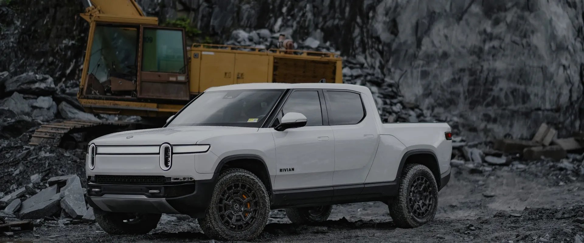 White electric truck parked near construction site - Rivian RT1 Wheels